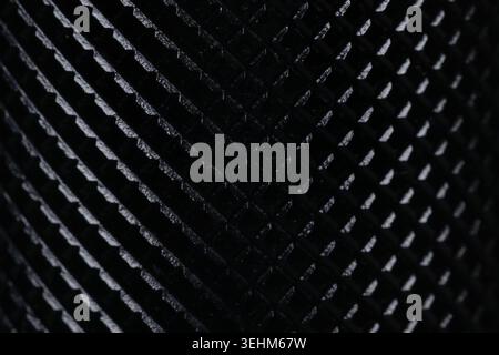 Macro shot of black textured metal surface with diamond knurling pattern. Close up of non-slip ribbed grip texture with selective focus, perfect for i Stock Photo