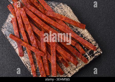 Food, Jerky dried fish sticks with salt and spices on a dark concrete background Stock Photo