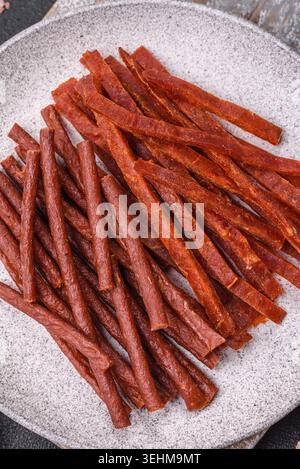 Food, Jerky dried fish sticks with salt and spices on a dark concrete background Stock Photo