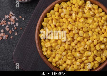 Food, Sweet yellow canned corn in bowl on dark concrete background Stock Photo