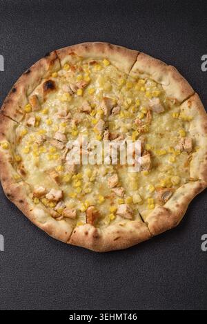 Food, Hawaiian pizza with chicken, pineapple, corn and cheese on dark concrete background Stock Photo