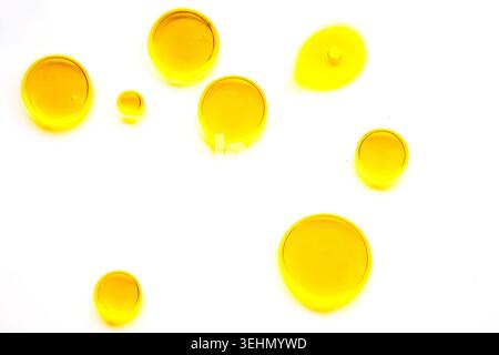 Minimal abstract oil background with translucent yellow spheres and bubbles floating on white space. Modern fluid texture for science, cosmetic, or de Stock Photo