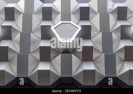 Abstract geometric metal facade in Dresden, Germany, Europe, featuring repeating polygon panels and a hexagonal light frame, creating a modern archite Stock Photo
