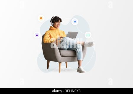 Young Person Using a Laptop in a Chair While Wearing Headphones and Looking Engaged in an Activity Stock Photo
