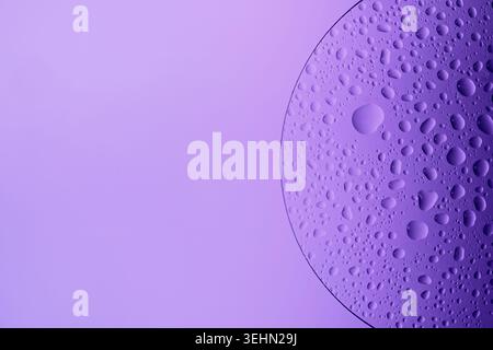 Water drops on glass slide, forming an abstract purple pattern Stock Photo