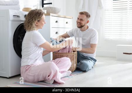 Happy couple doing laundry together at home Stock Photo