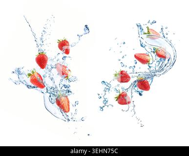 Fresh strawberries and water splashes in air on white background Stock Photo