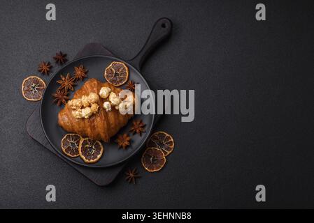 Food, Sweet crispy croissant with salted caramel and glazed popcorn on a dark textured background Stock Photo