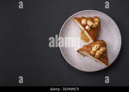 Food, Sweet crispy croissant with salted caramel and glazed popcorn on a dark textured background Stock Photo