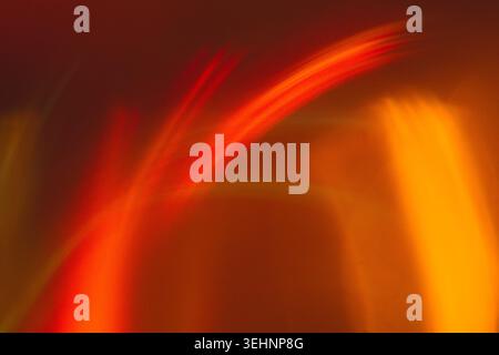 Abstract composition featuring colorful light trails in red, orange, and yellow against a blurred background, creating a sense of movement and energy Stock Photo