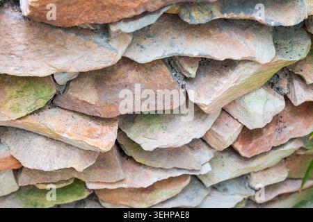 A close-up texture of a stacked stone wall or retaining wall Stock Photo