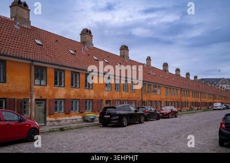 Distinctive yellow terraced houses in the Nyboder district of Copenhagen, Denmark built for the Danish navy sailors. Stock Photo