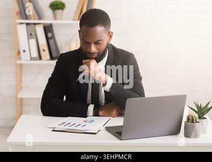 Serious businessman working on financial report in his office Stock Photo