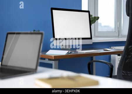 Desks with computers and stationery in office, closeup Stock Photo