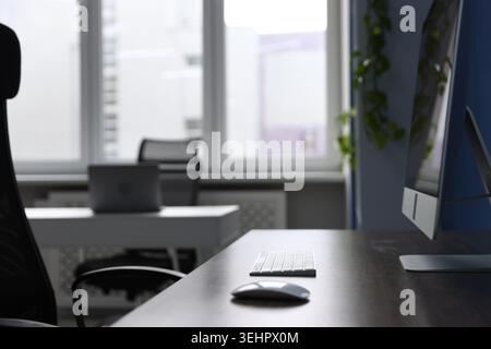 Desks with computers, chairs and decor in office, closeup. Interior design Stock Photo