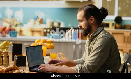 IT professional coding on laptop representing remote work for software development. Programmer writes source code and uses command-line tools, highlighting engineering and programming language. Stock Photo