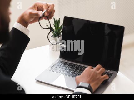 Cropped image of businessman using laptop with blank screen Stock Photo