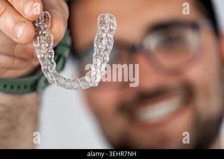 Man holding invisible aligner for tooth straightening Stock Photo