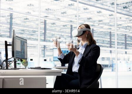 Female hardware developer in RD office using VR gear to design energy efficient semiconductors components. Professional using virtual reality tech to upgrade microchip equipment Stock Photo