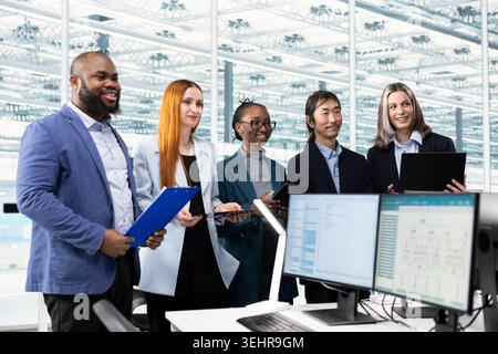 Monitoring microchip production quality, PC and cheerful engineering team in office troubleshooting yield issues. Overseeing PCB parts manufacturing, computers and multiethnic specialists Stock Photo