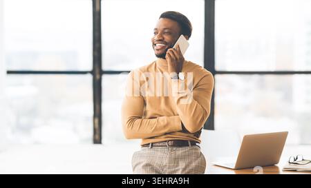 Happy afro businessman talking on cell phone Stock Photo