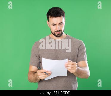Adult man making notes on paper documents in front of green screen Stock Photo