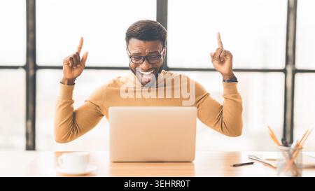 Ecstatic afro guy found new good idea Stock Photo