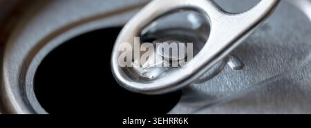 Close-up detail of an opened soda can top, focusing on the pull tab and metallic texture Stock Photo