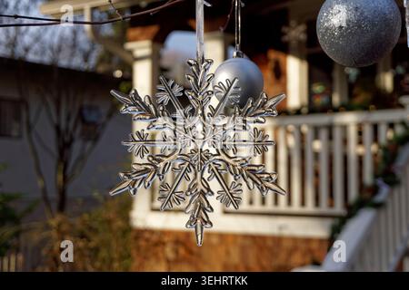 Close-up of clear glass snowflake Christmas ornament hanging outdoors Stock Photo
