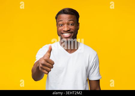 Smiling Afro Guy Gesturing Thumbs Up Approving Something, Studio Shot Stock Photo