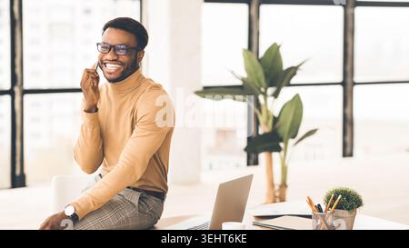 African man talking on cell phone at office Stock Photo