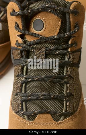 brown suede hiking boot with black woven laces close-up view, textured leather outdoor footwear Stock Photo