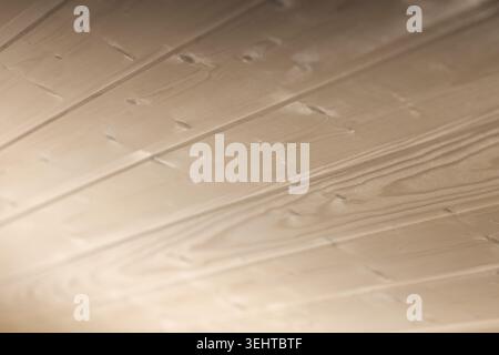 Close-up shot of light-colored wooden planks of ceiling, showcasing smooth grain and subtle shadows. Ideal background for interior, home decor, produc Stock Photo