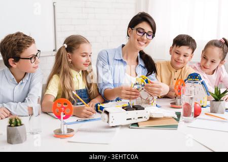 Kids Learning Robotics in a Classroom With a Teacher Guiding Them Through Projects Stock Photo