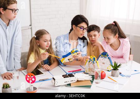 Children Engaging in Hands On Robotics Workshop With an Instructor Guiding Them Stock Photo