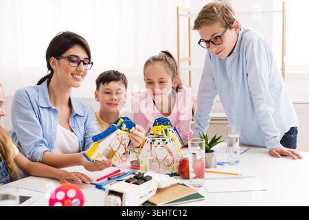 A Group of Children Works Together With a Teacher on Hands On Projects in a Well Lit Classroom Stock Photo
