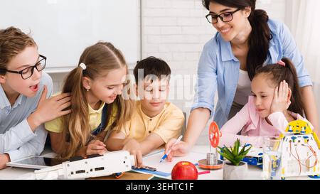 Children Engaged in a Creative Learning Activity With Robotics and Technology in a Classroom Stock Photo