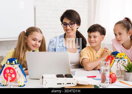 Engaging Classroom Activity With Children and Teacher Using Laptop for Learning Purposes Stock Photo