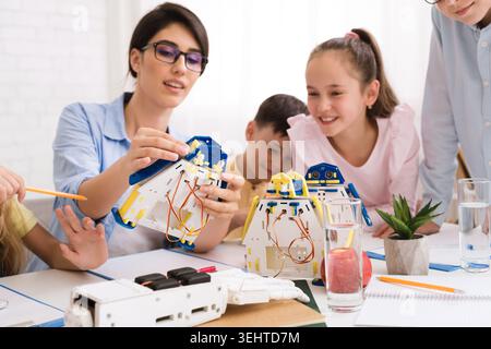 Children Engaging in a Robotics Workshop Guided by an Instructor Promoting Hands On Learning Stock Photo