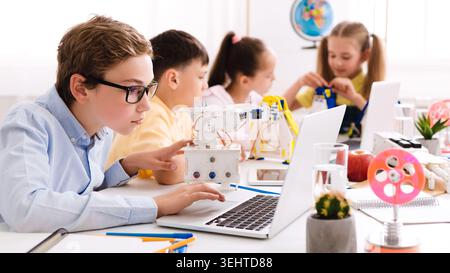 Children Engaged in Robotics and Programming Activities in a Modern Classroom Setup Stock Photo