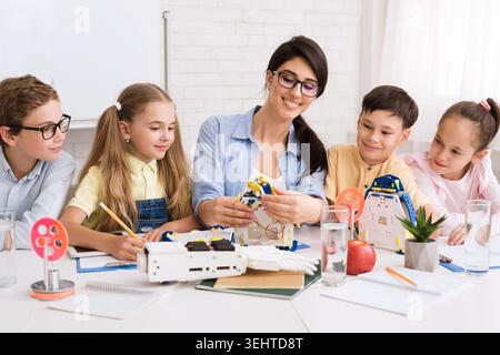 Children Engaged in Robotics Workshop With Instructor at Learning Center Stock Photo