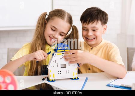 Children Engaged in Creative Play Building a Robot Together in a Classroom Setting Stock Photo