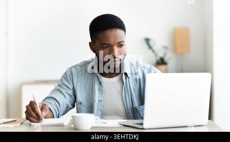 Unemployed man using laptop searching for vacancies online in internet Stock Photo