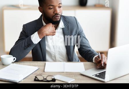 Confident businessman in formal suit working in modern office interior Stock Photo