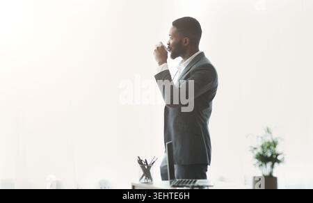 Business Professional Enjoying Coffee Break in Modern Office Setting During Daytime Stock Photo