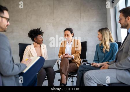 Diverse business people sitting in circle at group therapy session. Business coach training staff Stock Photo