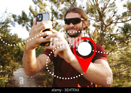 Man using smartphone to find taxi location on map during a travel outing in nature Stock Photo