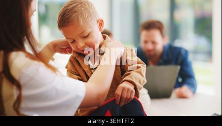 Child, home and getting ready for preschool with mom, education and help son with clothes or bonding. Woman, childcare and boy with backpack for Stock Photo