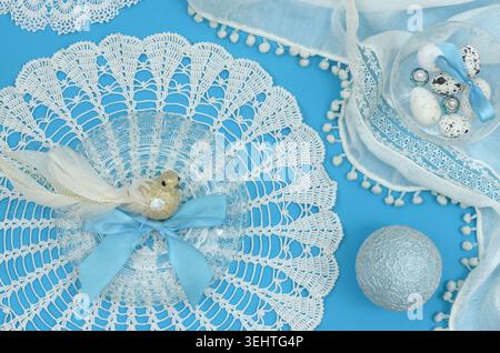 Blue, elegant decoration with vintage lace, decorative bird, egg and feminine decorations on blue table. Stock Photo