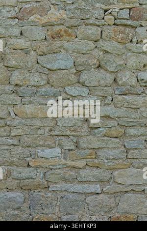 Close-up of texture or background of an old, weathered stone wall composed of irregularly shaped stones set in mortar, Saaremaa, Estonia, Europe. Stock Photo